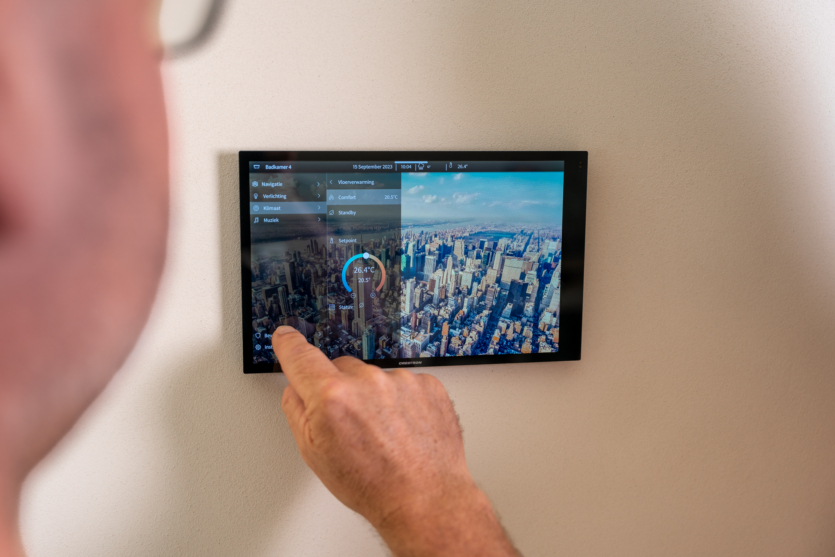 A man adjusts the indoor climate of his home with one simple touch on a screen thanks to a modern home automation system.